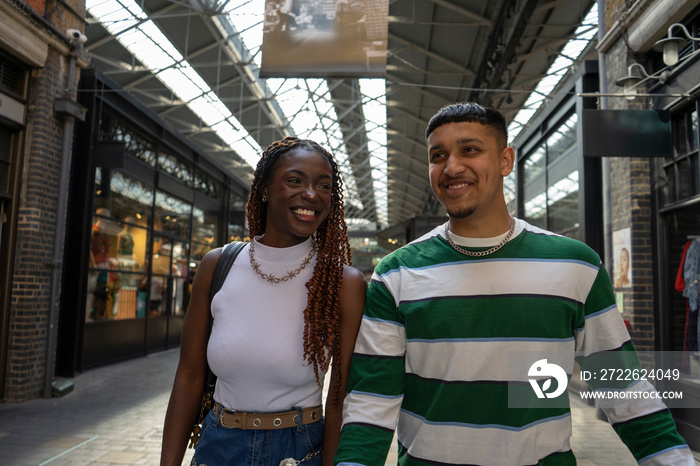 Smiling friends walking in cover market