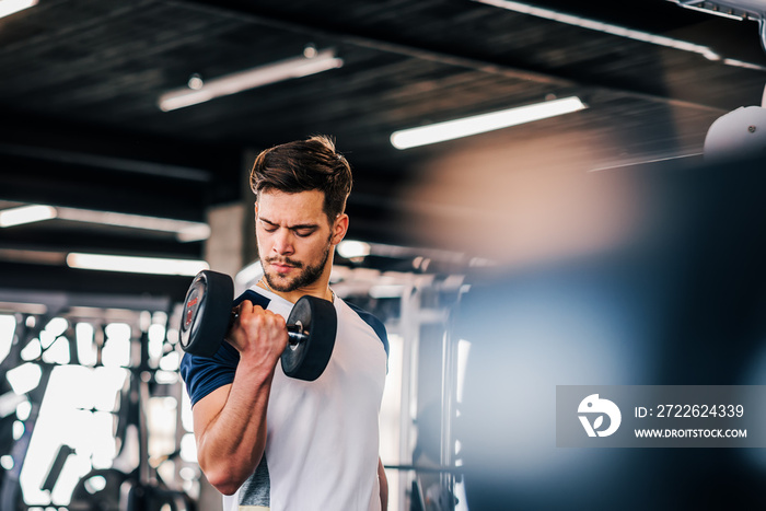 Young man in sportswear exercising with weights.