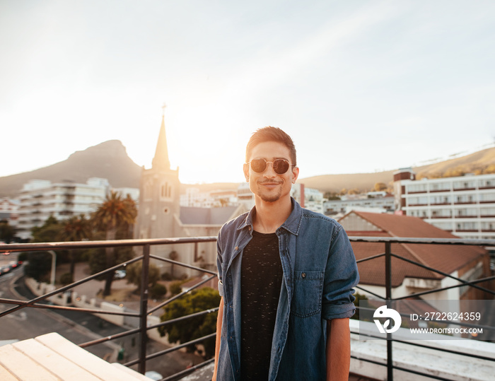 Handsome young man standing on the rooftop