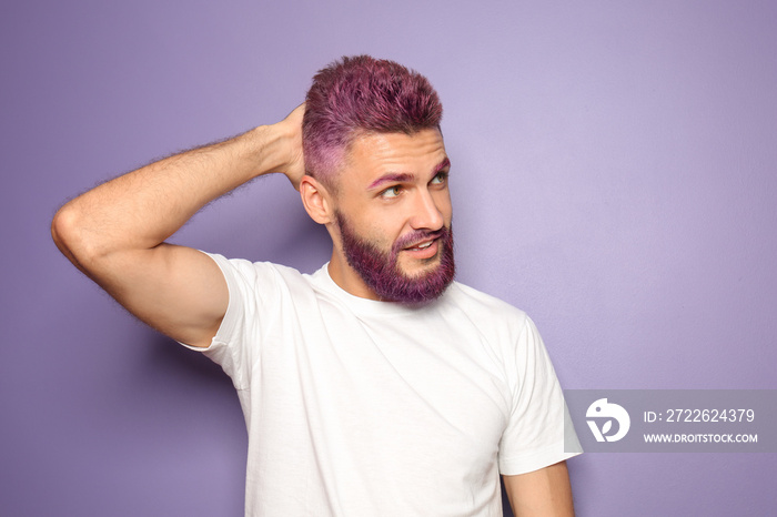 Portrait of handsome man with dyed hair and beard on color background