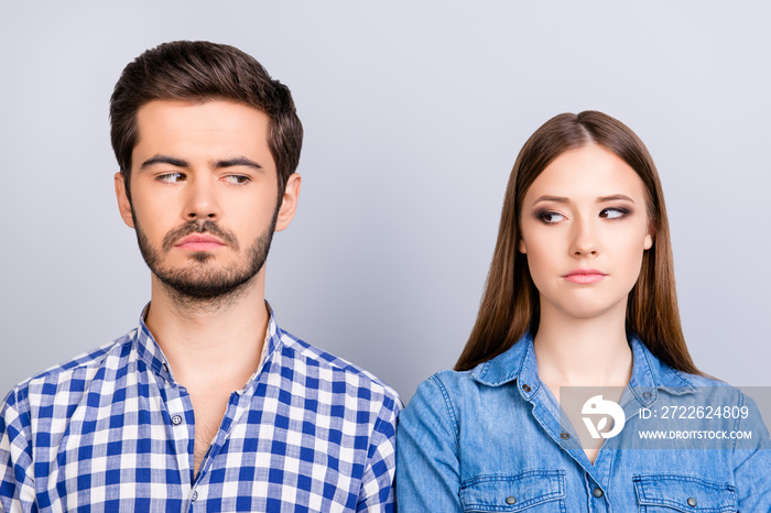 Mistrust and cheat problems. Annoyed couple is ignoring each other, but spy each other secretly, they stand on pure background in casual shirts