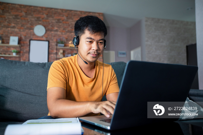 Asian businessmen is using notebook computers and wear headphones for online meetings and working from home.