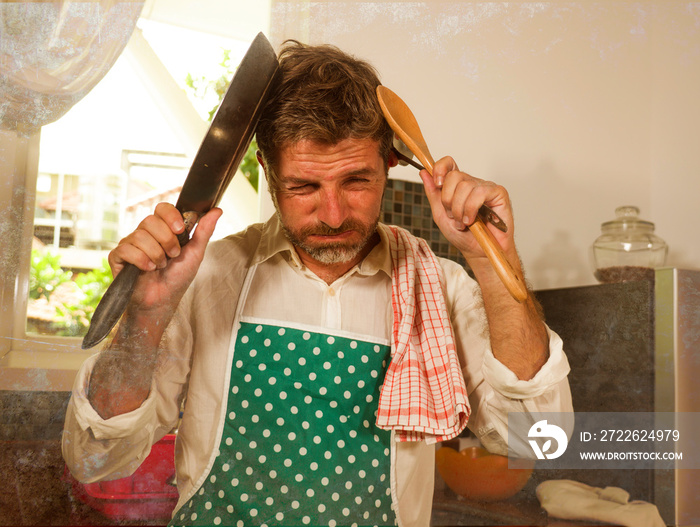 dramatic grunge portrait of 30s to 40s house husband or single man in kitchen apron doing domestic chores washing dishes or cooking in stress feeling frustrated