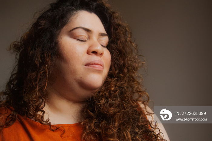 Plus-sized Sri Lankan woman with vitiligo meditating in her bedroom