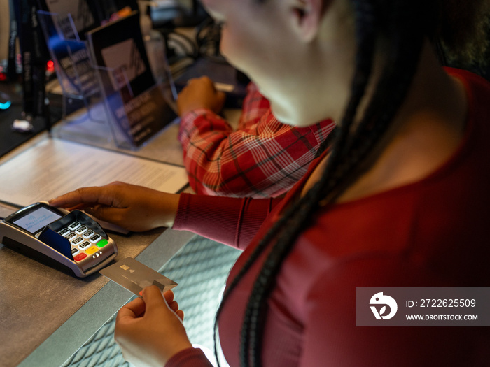 Woman paying with credit card by checkout desk