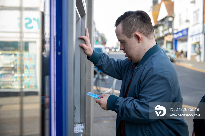 Man using cash machine in street