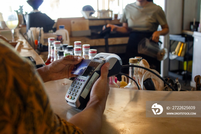 Man paying with card in beach bar