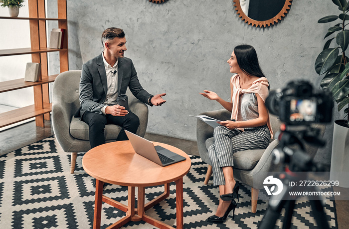 Female journalist interviewing business man