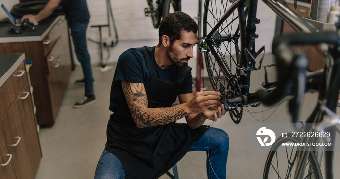 Mechanic repairing a bicycle in workshop