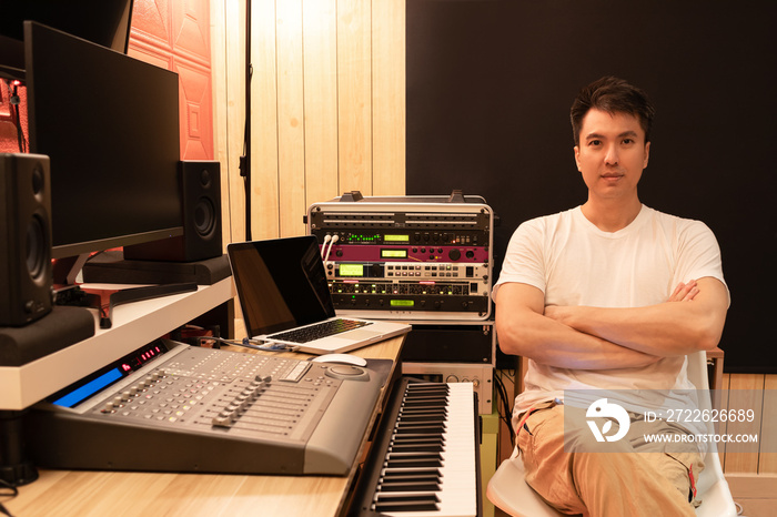 portrait of asian young professional music producer, composer, sound engineer with audio recording equipments in studio