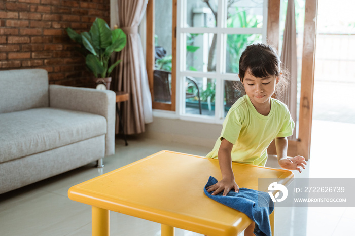 little kid cleaning up the table by herself