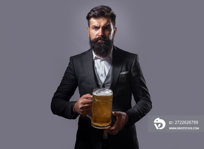 Hipster with beard and mustache in suit drinks beer. Germany Bavaria. Beer time. Handsome barman holding a pint of beer.