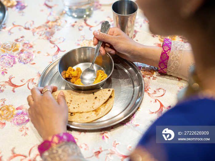 Woman eating traditional Indian food at home