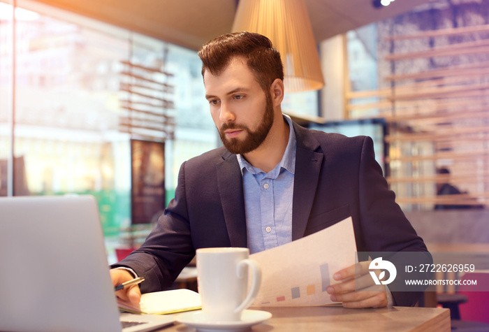 Handsome marketing manager working in cafe