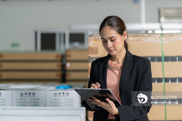 Portrait of young woman worker working writing checking at warehouse. Inspection quality control