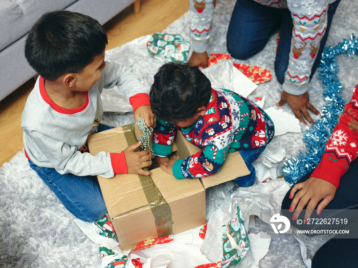 Family with sons opening Christmas presents