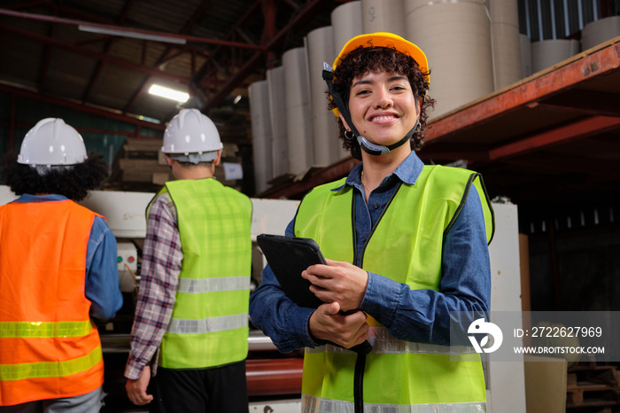 Portrait of safety uniform female engineer worker and hard hat with tablet looks at camera, happy smile and cheerful, industry jobs success, achievement, professional technician manufacture factory.