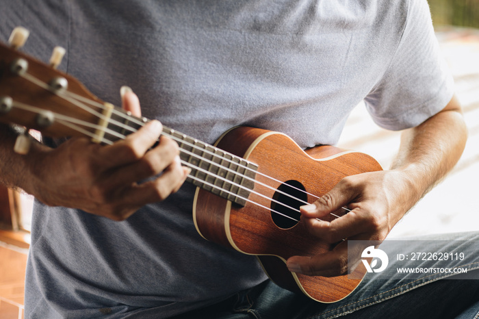 Close up Young man playing ukulele