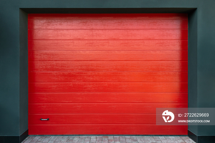 New bright red garage door elevation close up. Entrance to the garage.