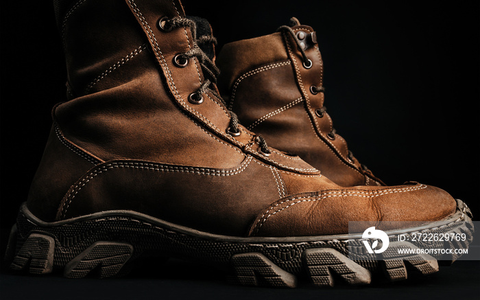 Military tactical boots on black background.