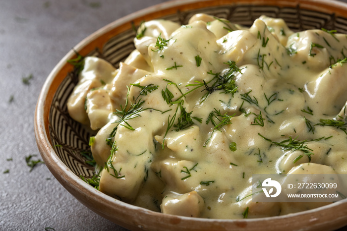 Chicken meat with sour cream and fresh chopped dill in plate