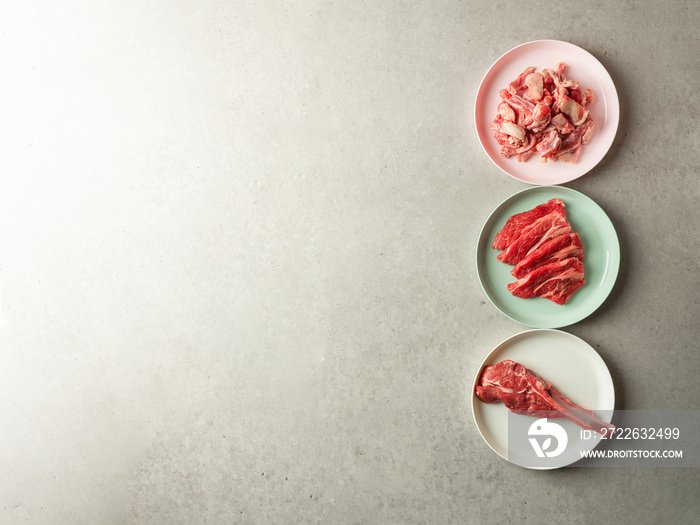 Variety of raw meat and lamb on colorful plates