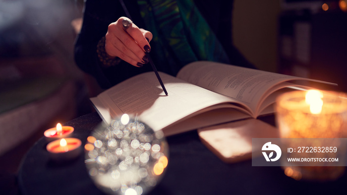 Woman fortune-teller’s hands, predictions books, predictions bal