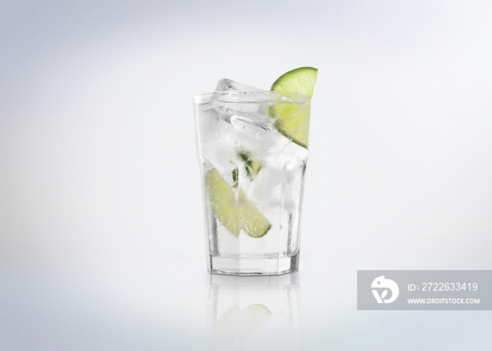 A glass of Gin Tonic cocktail  drink with ice cubes (on the rocks) and a slice of lime. Isolated on white background.