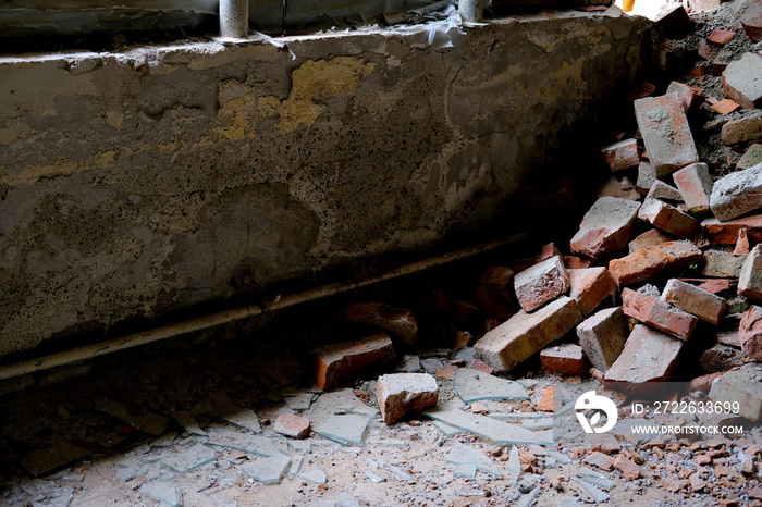 basement air raid shelter, ruined room in abandoned building with broken windows without glass, pile of bricks lying around, concept of destruction of buildings from bombing and rocket attacks