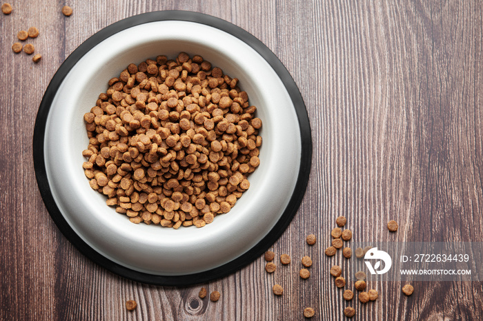 A bowl of dog food on a wooden floor.