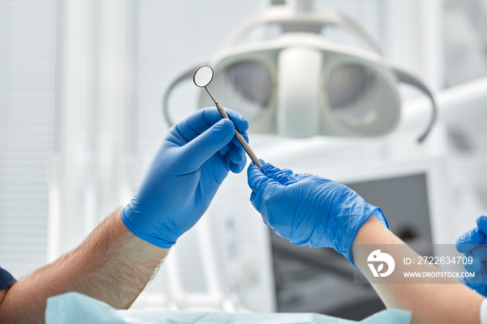 Close-up of the hands of a dentist and nurse surgeon over an operating room during a dental implant operation