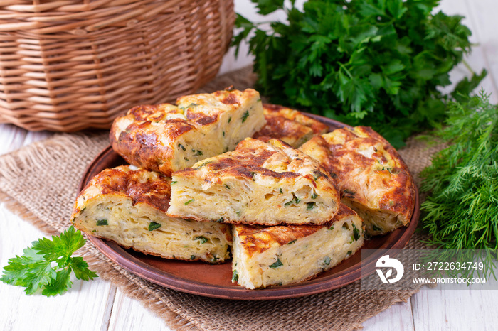 Pie with zucchini, cheese and herbs on the table