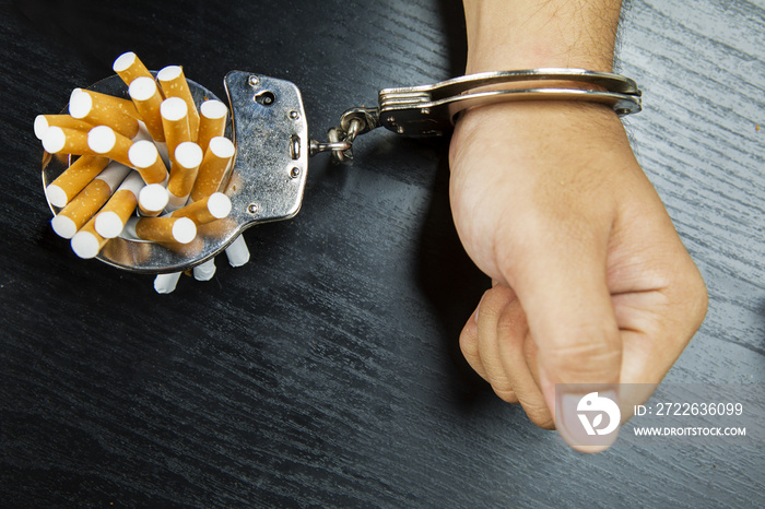 Man’s arm bonding cigarettes on the table