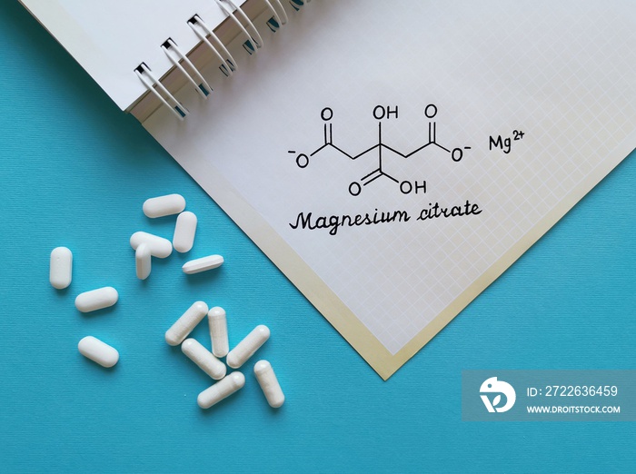 Structural chemical formula of magnesium citrate molecule with white pills. Magnesium citrate is a magnesium preparation in salt form with citric acid, it is used medicinally as a saline laxative.