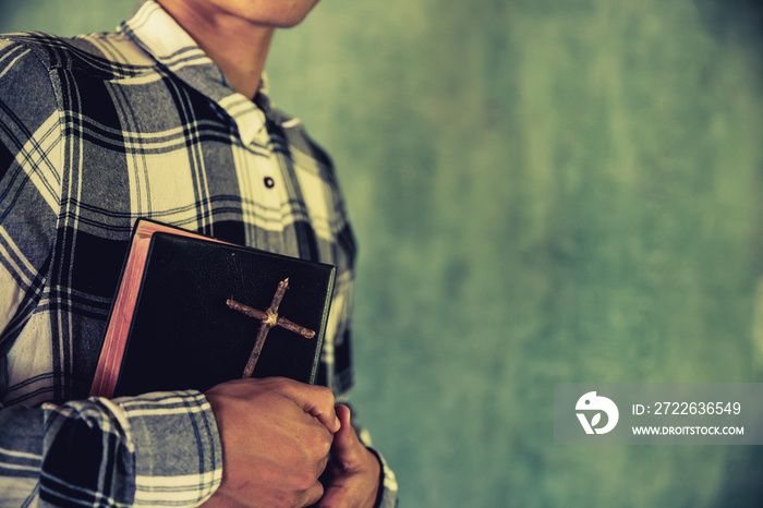 A young man holding a bible in his hands