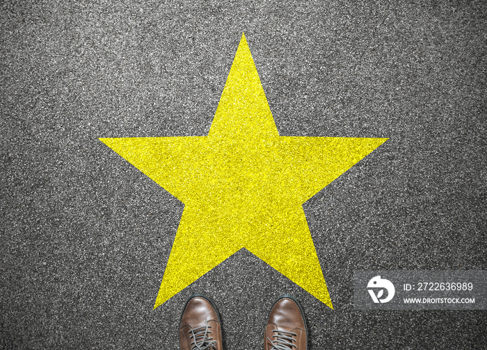 big yellow star on floor with businessman shoes