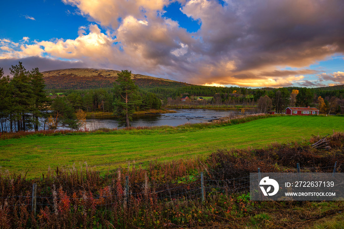 Sunset over a wooden cabin and Glomma River in Innlandet county, Norway