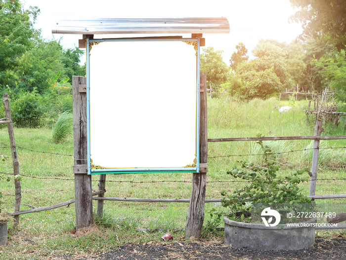 Blank wood board in the public park with green trees background.