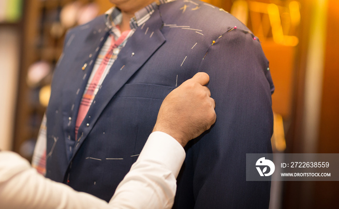 Tailor working with custom made suit