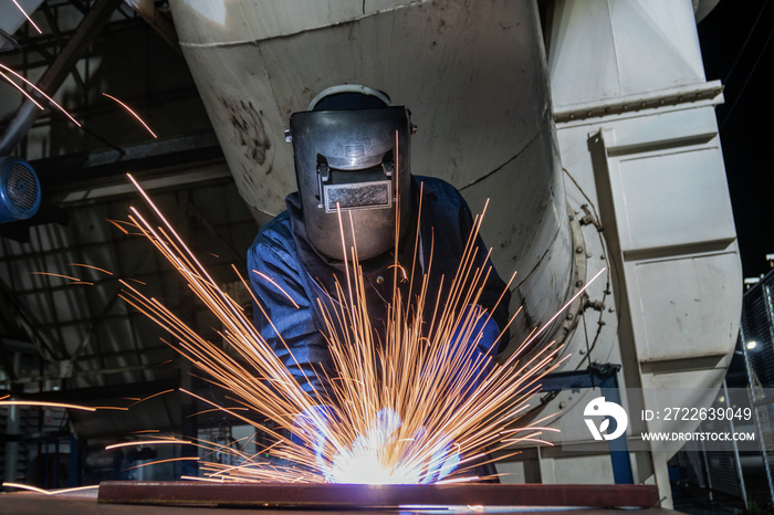 Industrial worker is welding repair steel part