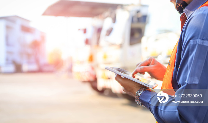 Truck drivers hand holding tablet checking the product list,Driver writing electronic log books,spot focus.