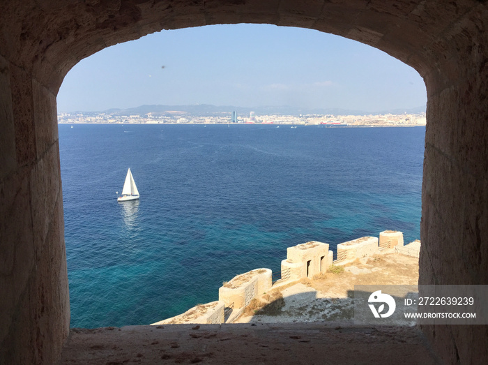 Panoramic view of Marseille seen through an embrasure at Château d’If - a fortress and former prison located on the Île d’If, the smallest island in the Frioul archipelago, next to Marseille.