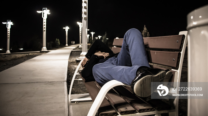 student sleeping on a bench in the alley at night