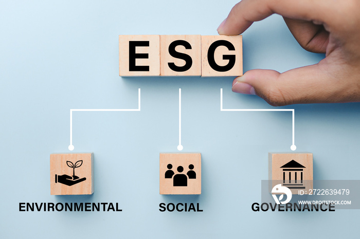 Hand putting wood cube in ESG icon concept for environmental, social, and governance in sustainable and ethical business