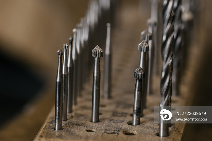 Front view of a set of various tools placed on a wooden desk in a workshop