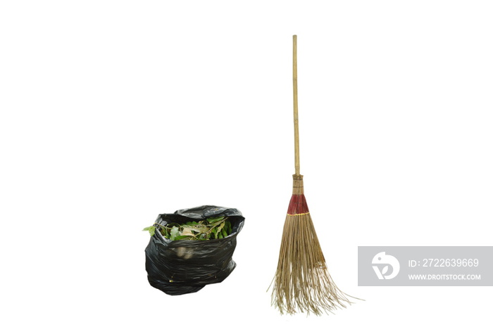 garden broom with long wooden handle and plant scrap in black plastic garbage bag on white background