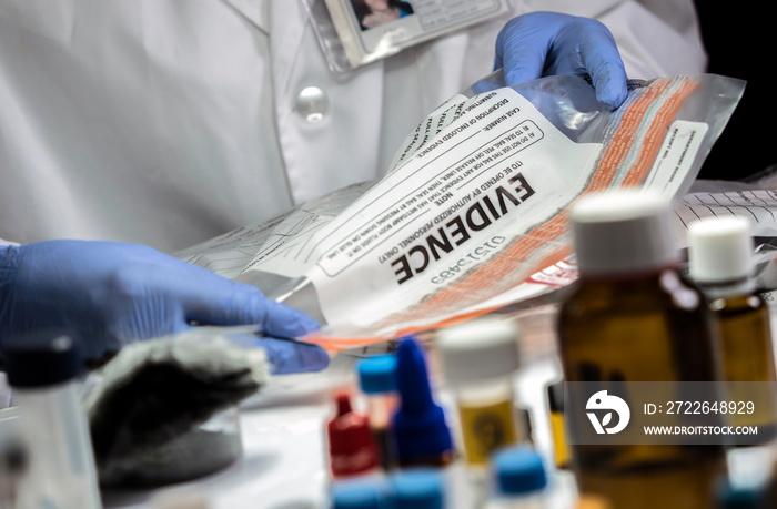 Police specialized taking sample of a bag of evidence in forensic laboratory, conceptual image