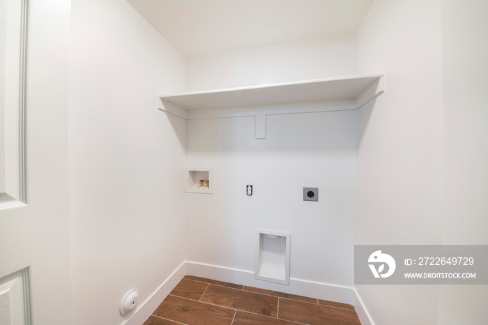 Clean small white empty laundry room with built in laundry connections