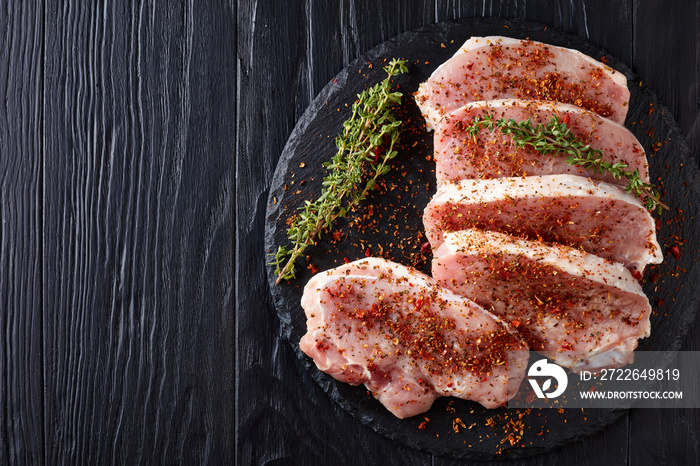 Top view on chops of pork, black background