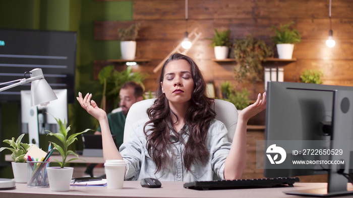 Relaxed zen businesswoman with closed eyes standing in yoga position meditating during work pause in startup business company office. Entrepreneur worker concentrating on breathing